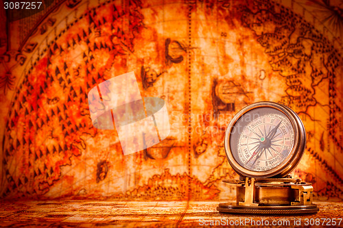 Image of Vintage compass lies on an ancient world map.