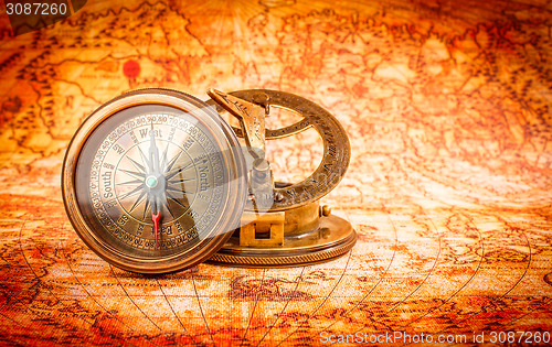 Image of Vintage compass lies on an ancient world map.