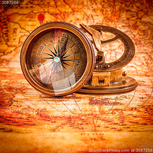 Image of Vintage compass lies on an ancient world map.