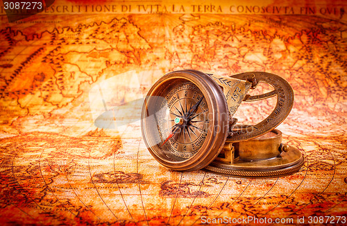 Image of Vintage compass lies on an ancient world map.