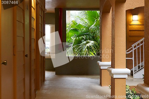 Image of outside hallway with with doors and rain