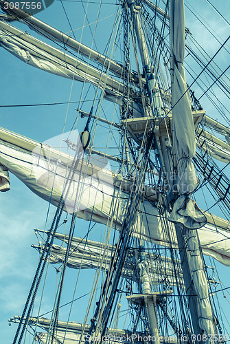 Image of Sails and tackles of a sailing vessel on a background of the sky