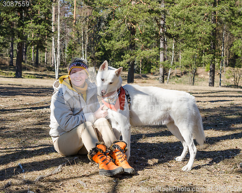 Image of The woman with a white dog in a wood