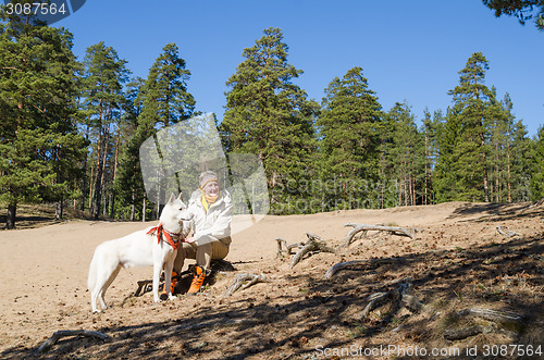 Image of The woman with a white dog in a wood