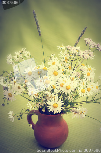 Image of Bouquet of wild flowers in a clay pot, close-up  