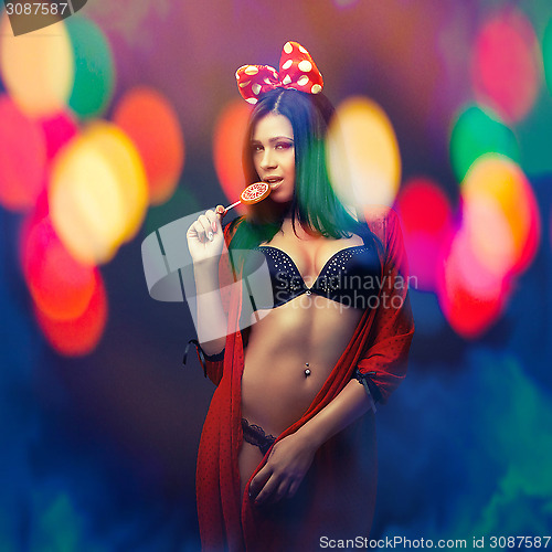 Image of attractive girl in colorful light party with lolly