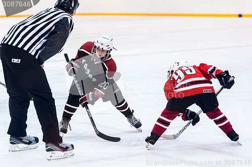 Image of Puck playing between players of ice-hockey teams