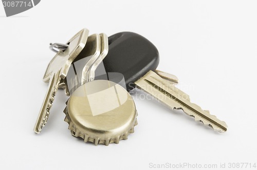 Image of car key and bottle cap in close up