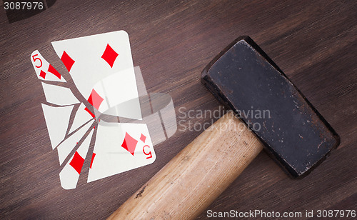 Image of Hammer with a broken card, five of diamonds