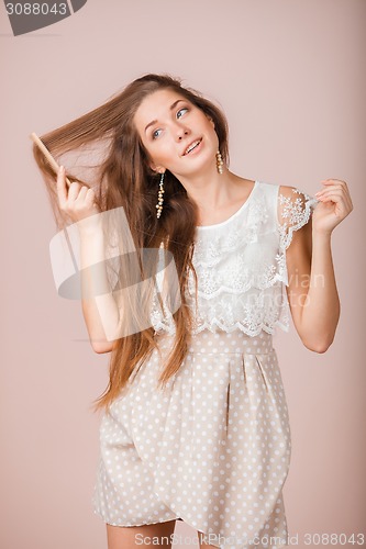 Image of Smiling Girl combs her hair