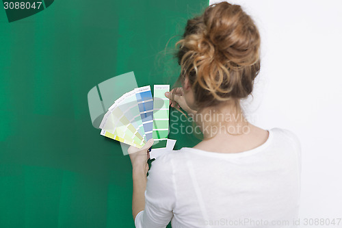 Image of Woman with color plates in front of a green wall
