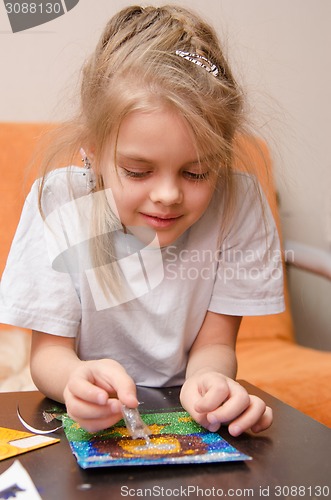 Image of Five year old girl making sand applique