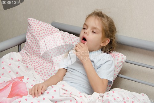 Image of Diseased girl lying in bed coughing