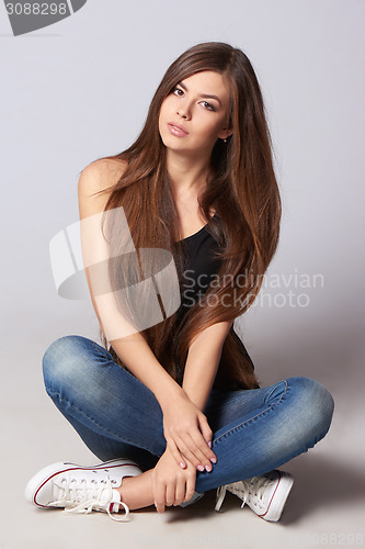 Image of Teen woman sitting on floor