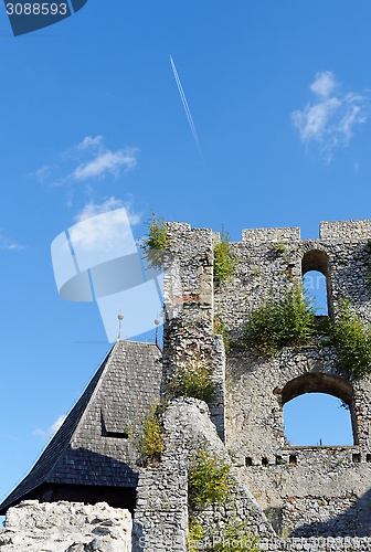 Image of Contrail of the jet plane above ruin of Celje medieval castle in Slovenia