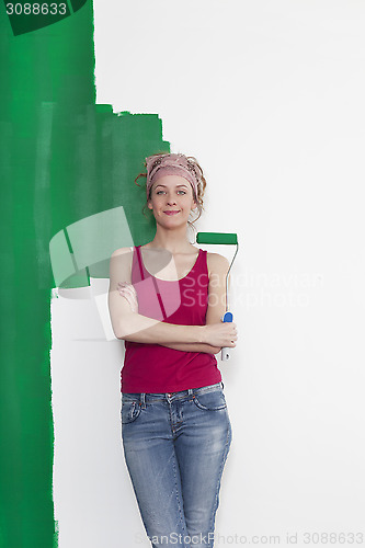 Image of Woman with paint roller in front of wall