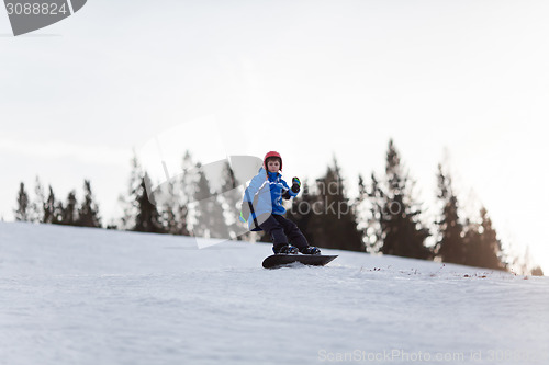 Image of Young boy riding snowboard