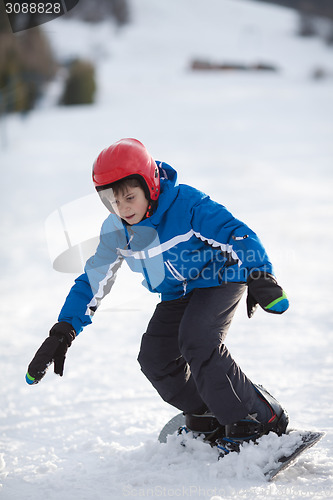 Image of Young boy riding snowboard