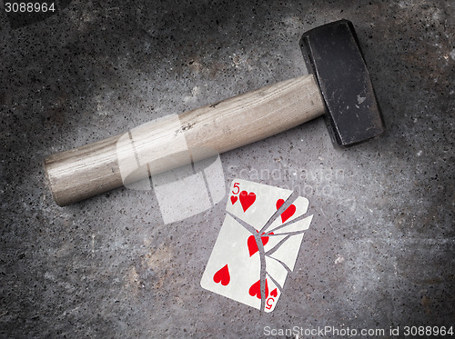 Image of Hammer with a broken card, five of hearts