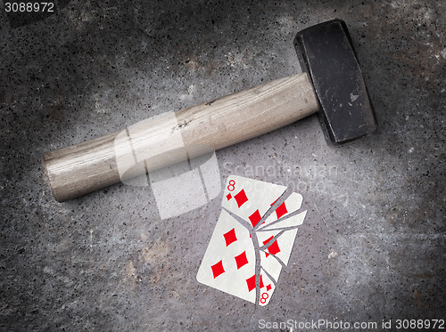 Image of Hammer with a broken card, eight of diamonds