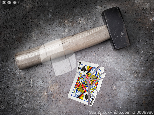 Image of Hammer with a broken card, queen of spades