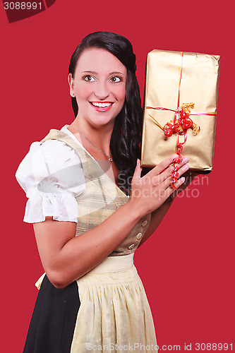 Image of Young woman with dirndl and a great gift in hand