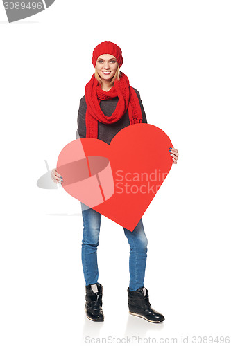 Image of Full length girl holding up a red cardboard heart