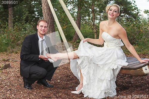 Image of Groom takes his bride to the shoes.