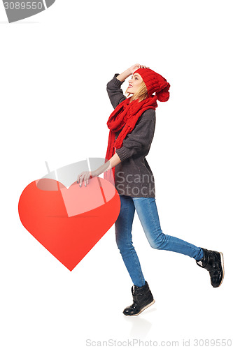 Image of Full length girl holding up a red cardboard heart