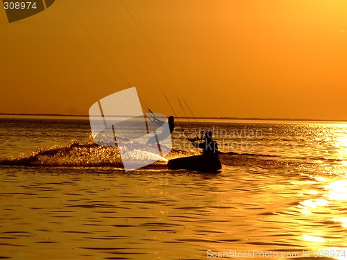 Image of Silhouette of a two kitesurf on a gulf on a sunset