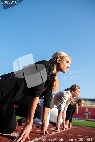 Image of business people running on racing track