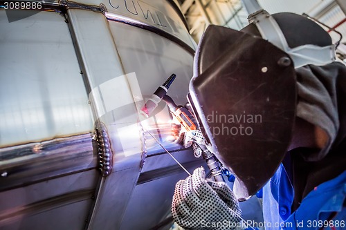 Image of Man welding with reflection of sparks on visor. Hard job. 