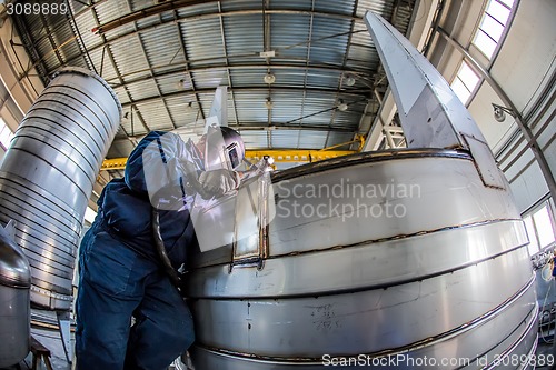 Image of Man welding with reflection of sparks on visor. Hard job. 