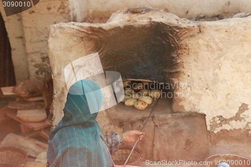 Image of Bread making - checking on bread with an iron rod