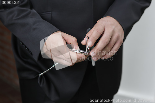 Image of Groom looks at the clock