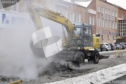 Image of the excavator digs out break on a heating main. Tyumen