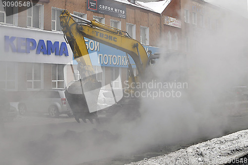 Image of the excavator digs out break on a heating main.