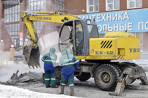 Image of the excavator digs out break on a heating main.