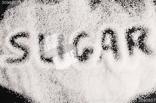 Image of The word sugar written into a pile of white granulated sugar