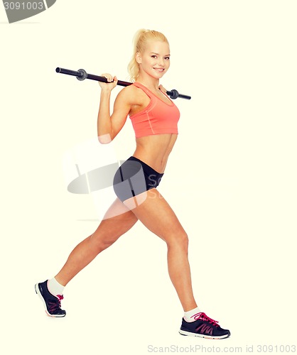 Image of smiling sporty woman exercising with barbell