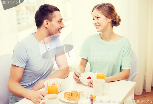 Image of smiling couple having breakfast at home