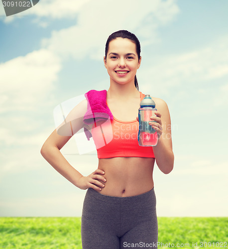 Image of sporty woman with towel and water bottle