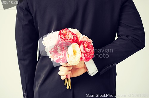 Image of man hiding bouquet of flowers