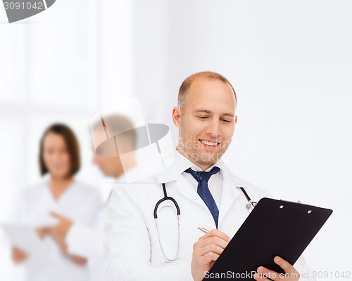 Image of smiling male doctor with clipboard and stethoscope