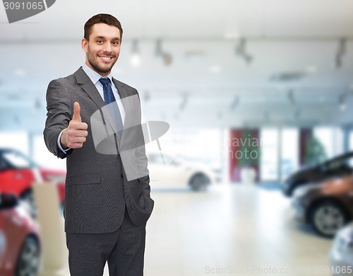 Image of smiling businessman showing thumbs up