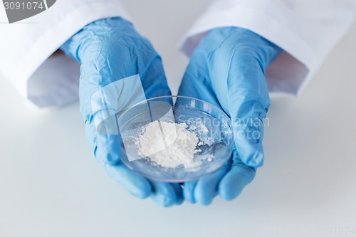 Image of close up of scientist holding petri dish in lab