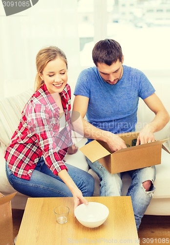 Image of smiling couple unpacking kitchenware