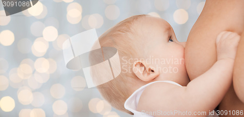 Image of close up of mother breast feeding adorable baby