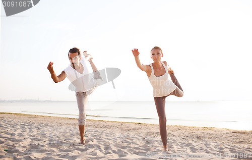 Image of couple making yoga exercises outdoors