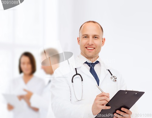 Image of smiling male doctor with clipboard and stethoscope